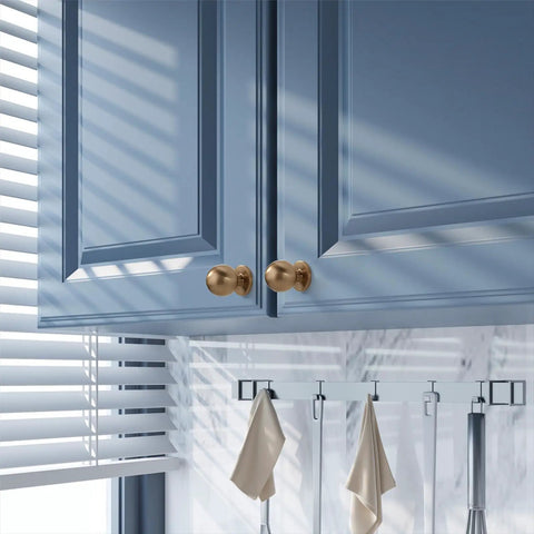 Champagne Bronze Cabinet Knobs Set Of 10 for kitchen cabinets and drawers, shown installed on blue cabinet doors with soft shiny finish.