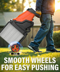 Person pushing Powerful 15-Amp Wood Chipper Shredder with 50L Collection Bin, smooth wheels, yard background, morning light