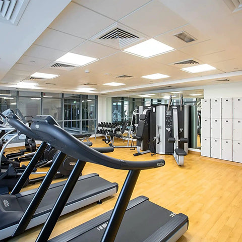 Modern gym interior with equipment and lockers for exercise and storage.