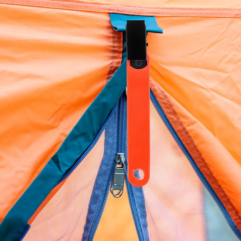 Orange Glow Reflective Trail Marker Clips with glow tape attached to tent, waterproof for hiking and hunting outdoors.