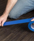 Duck Brand blue painter's tape, 0.94 in x 60 yd, being unrolled from a roll