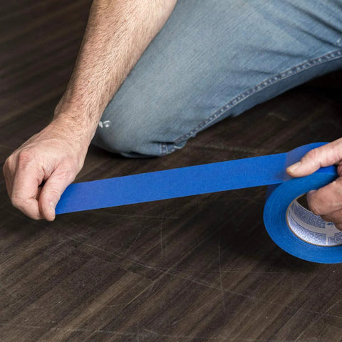 Duck Brand blue painter's tape, 0.94 in x 60 yd, being unrolled from a roll