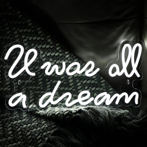 "It was all a dream" neon sign in warm white on textured background.