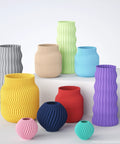 3D-printed vases with matte finish and wavy ribbed texture in a multicolor set of various sizes.