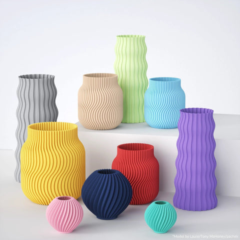 3D-printed vases with matte finish and wavy ribbed texture in a multicolor set of various sizes.