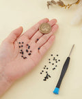 Premium Wallet Replacement Screw Kit With Mini Screwdriver, 50 Heavy Duty Stainless Steel Fasteners in hand next to a coin.