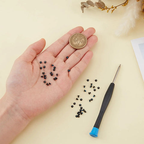 Premium Wallet Replacement Screw Kit With Mini Screwdriver, 50 Heavy Duty Stainless Steel Fasteners in hand next to a coin.