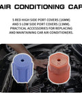 Close-up of blue and red valve caps for 10Pcs A C System Valve Cap Set for R134a Vehicles with visible car engine background.
