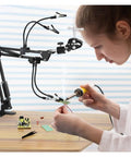 Person using Third Hand Soldering Station With Adjustable Gooseneck Arms And PCB Holder Welding Help Tool For Precise Desoldering And Electronics Repair Perfect For DIYers Makers And Hobbyists