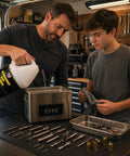Father and son pour Ultrasonic Gun Cleaner Concentrate 128 Oz Makes Up To 200 Gallons No Nonsense Deep Clean For Pistols Rifles Brass And All Firearm Components With Easy Mixing And Boss Level Ultrasonic Action into a metal ultrasonic cleaner