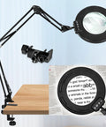 Ultra Long 12X And 30X Pro Grade Magnifying Lamp With Light And Clamp on desk, showing magnified text. Swivel arm workbench light.