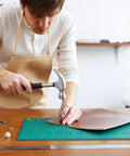 Person using Leather Hole Punch Set 1.5mm-5mm For Belts And Leather Crafting, Round Hollow Punches on leather sheet with hammer