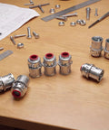 Premium 3/8 Inch MC Cable Connectors 25 Pack Top Shelf Zinc Die Cast Metal Clad Fittings for 1/2 Inch Knockout on workbench.