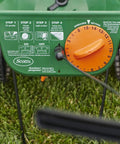 Edge Guard Mini Broadcast Spreader With Calibrated Settings And Wheels on grass, showing control dial and instructions
