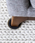 Heavy Duty Round Plastic Carpet Furniture Sliders Glide Your Couch Tables And Dressers Smooth As Butter Pads 3.5 Inches Wide under a wooden sofa leg.
