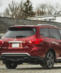 Red Nissan Pathfinder with 7 Inch Replacement Radio Antenna Mast For Nissan Pathfinder Rogue Murano Cube Juke Versa Kicks Leaf 370Z 350Z NV200 Cars Durable Antenna Compatible With 2003-2023 Models visible on roof.