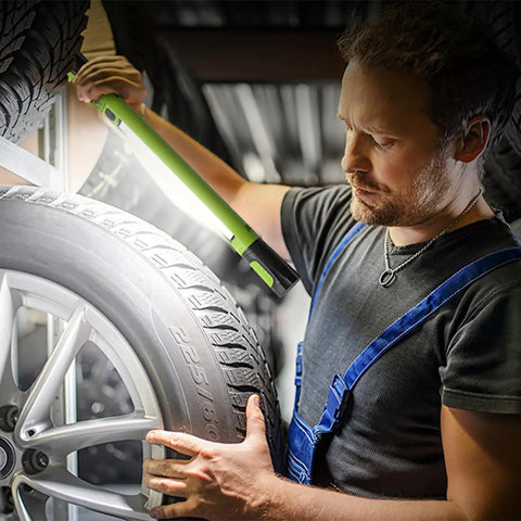 Mechanic using Cordless Underhood Work Light With Magnetic Base, 3000 Lumen LED, 5200mAh Rechargeable Battery to inspect tire