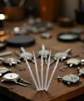 Five Piece Silver Steel Watch Stem Crown Kit For NH35 NH36 NH38 NH39 Movements on a wooden table with watch tools