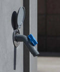 Close-up of a Removable Outdoor Faucet Hose Connector with Quick Connect on a wall, slate gray with blue handle.