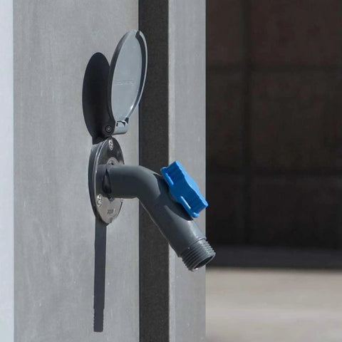Close-up of a Removable Outdoor Faucet Hose Connector with Quick Connect on a wall, slate gray with blue handle.