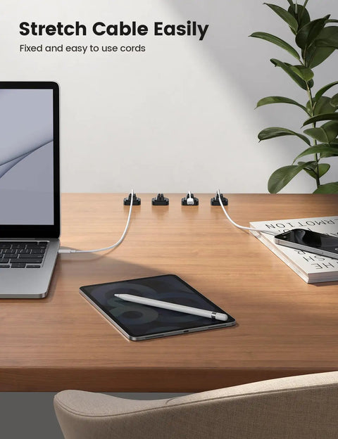 5 Pack Cable Spring Holder Clips For Desk Organization on a wooden desk holding USB and phone cables in a tidy arrangement