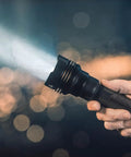 Hand holding ProTac HL 5-X 3500 Lumen Multi Fuel Tactical Flashlight With Rechargeable Batteries And USB Cable, beam illuminating
