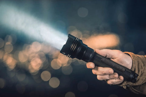 Hand holding ProTac HL 5-X 3500 Lumen Multi Fuel Tactical Flashlight With Rechargeable Batteries And USB Cable, beam illuminating