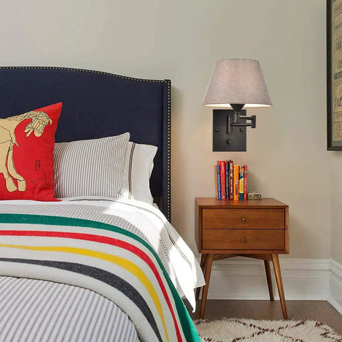 Bedroom view with Plug-In Wall Sconce Set Of 2 With Swing-Arm Lamps, grey fabric shade, on black finish above wooden nightstand