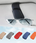 Heavy Duty Magnetic Sunglass Holder For Car Sun Visor With Secure Snap Clip And Soft Leather Wrap One Handed Eyewear Organizer with sunglasses attached.