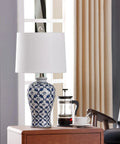 Blue Ceramic Table Lamp With White Fabric Shade Chinoiserie Urn Style Hand Painted Detail on wooden table beside coffee set