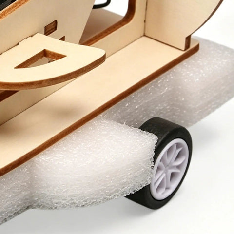 Close-up of a Wooden Vehicle Model Kit For Hands On Mechanical Engineering Fans showcasing wooden base and wheel detail.