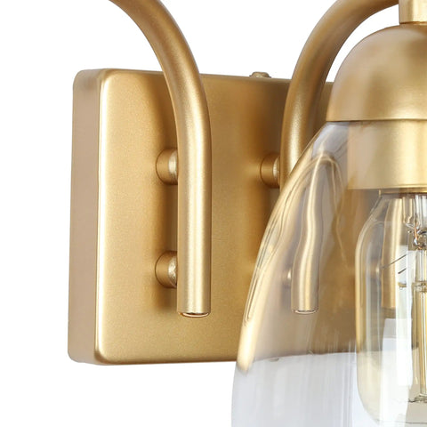 Close-up of gold finish base and clear glass shades in Gold Vanity Light Fixture Set With Clear Glass Shades, Modern 3 Light Over Mirror Bath Lighting, 22 Inch Long, Sleek Gold Finish Bath Bar Lights That Look Totally Lit.
