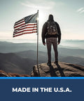 Hiker standing on a rock with American flag, symbolizing Ape Canyon Outfitters 3 Step Aider For Hunters And Arborists Lightweight Tree Climbing Tool Made In USA Coyote Ready For Safe Elevations And Quick Escalation In The Field.