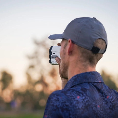 Person using Bang For Your Buck Budget Friendly Golf And Hunting Rangefinder With Seven X Magnification, 1200 Yard Distance outdoors