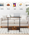 Mobile Side Table On Wheels Height Adjustable Laptop Cart For Living Room And Bedroom C Shaped Bed End Table With Edge Stopper Must Have Portable Rolling Desk For Your Couch Or Bed Rustic Brown Finish in front of a sofa with various items displayed above.