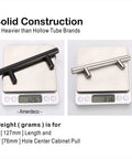 Comparison of solid oil rubbed bronze vs hollow tube cabinet pulls on scales showing weight difference