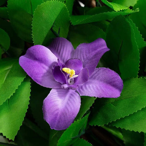 Close-up of purple flower with yellow center on green faux ivy leaves from Expandable Fence Privacy Screen For Balcony And Patio No Fuss Installation Faux Ivy Fencing Panel 16x45 To 92 Inches Willow Frame With Decor Ivy Leaves Low Maintenance Backyard Decor.