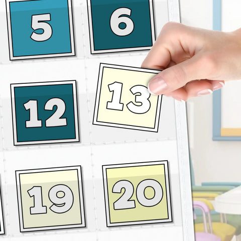 Hand placing card labeled '13' in Durable Nylon Classroom Calendar Pocket Chart For 2.75 By 2.75 Cards With 24 Inch Hanging