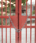 20 Inch Heavy Duty Stainless Steel Gate Chain Lock With Dual End Carabiners For Outdoor Fences Pet Cages And Corral Use installed on a red gate