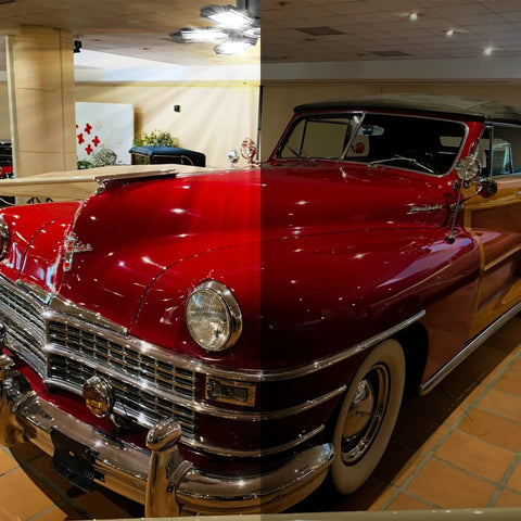 Vintage red car with a split lighting effect, highlighting the vehicle's classic design in an indoor showroom setting.