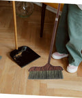 Long Handle Heavy Duty Broom With Soft Beveled Bristles For No Sweat Dust Removal And Quick Corner Cleanup Solid Workhorse Crushes Daily Kitchen Grime Indoors Or Outside Smooth Operator Approved on wooden floor with dustpan.