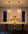 Kveosv 2 Pack Kitchen Island Pendant Lights, 8" Clear Glass Shade over dining table in modern setting, black metal fixtures.