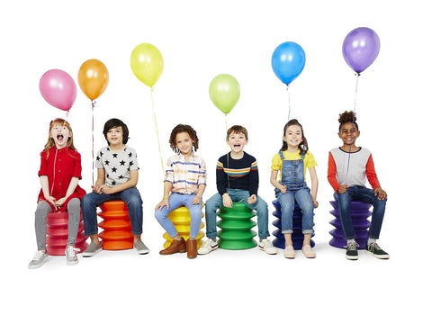 Active Sitting Stool for Kids Ergonomic Wiggle Friendly Desk Chair Designed to Boost Focus and Concentration Colorful Orange Stool for Homework Learning Play and Creative Projects with children seated holding balloons