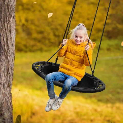 Girl in yellow jacket swinging on 40 Inch Flying Saucer Tree Swing For Kids Heavy Duty Outdoor Disc Round Swing Supports Up To 220 Lbs