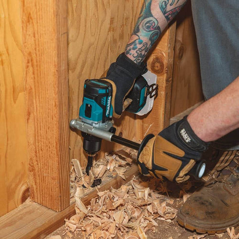 Person using Compact 18V Hammer Driver Drill With Brushless Motor, 1/2 Inch Chuck, Tool Only on wood surface in construction site.