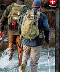 Black first-aid pouch with red cross on a tactical belt, beside a tan MOLLE backpack outdoors.