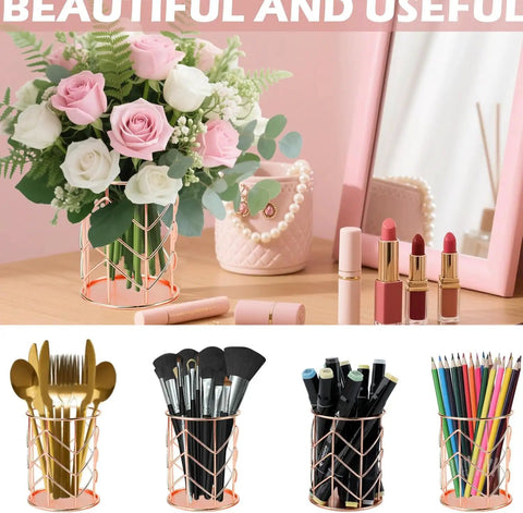 Rose gold wire holders and accessories on a wooden desk with flowers and lipsticks in a decorative setting.