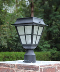 Solar Powered LED Post Cap Light for 3 Inch Fitter Mount Outdoor Cast Aluminum Lamp With Bright Warm White Glow for Pillar Pathway Driveway Garden Landscape and Yard mounted on a brick pillar with greenery background.