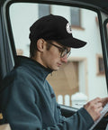 Man wearing Lightweight All Season Hat for Women and Men, Adjustable Cap With Breathable Fit sitting in vehicle reading
