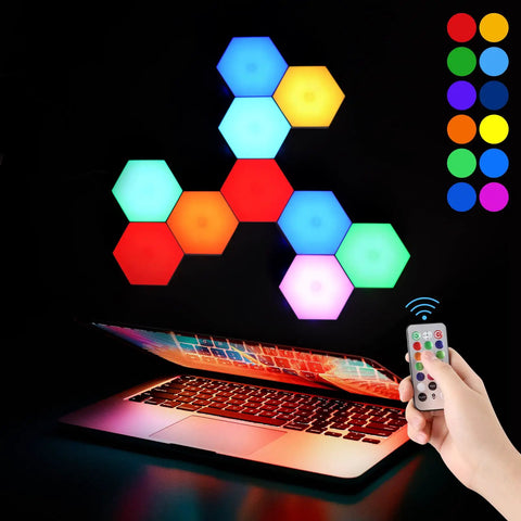Hexagon LED Wall Panels 10 Pack With Remote And Touch Control RGB 13 Color Lights arranged above open laptop with hand holding remote